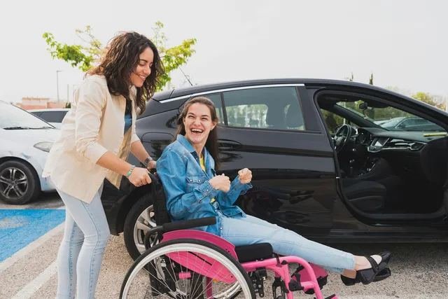 A young woman celebrating her independence, being supported into her car
